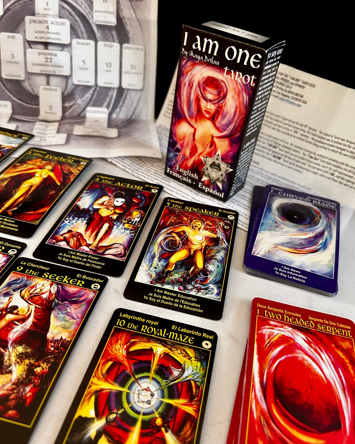 Collection of tarot cards and a box labeled 'I am one Tarot' on a surface.