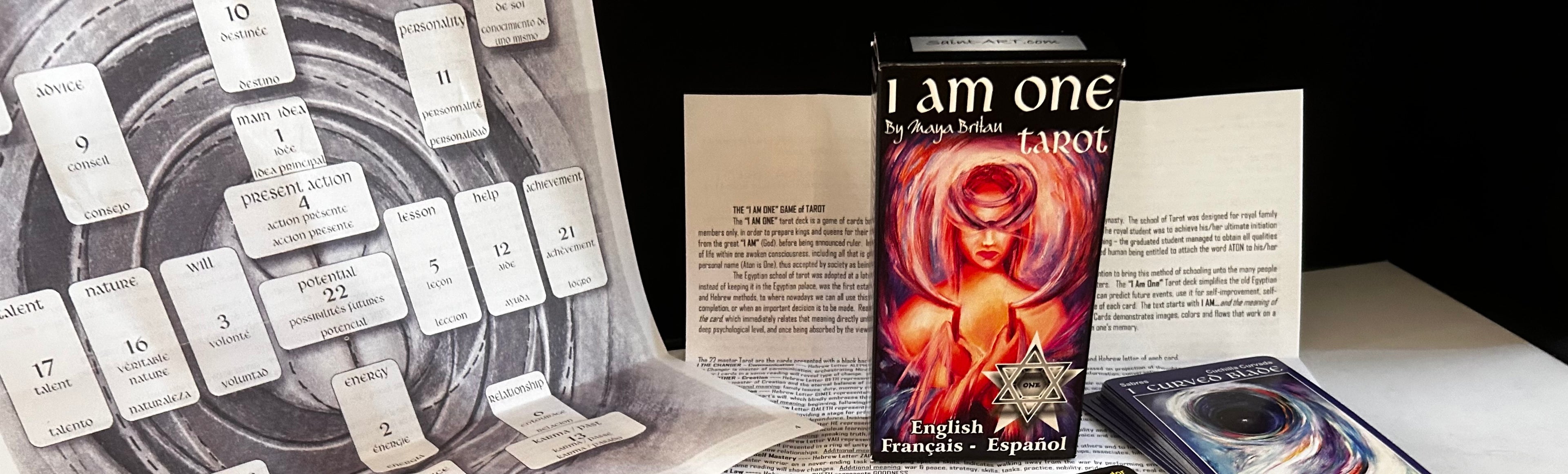 Card deck titled 'I am one' with tarot cards and a book on a table.