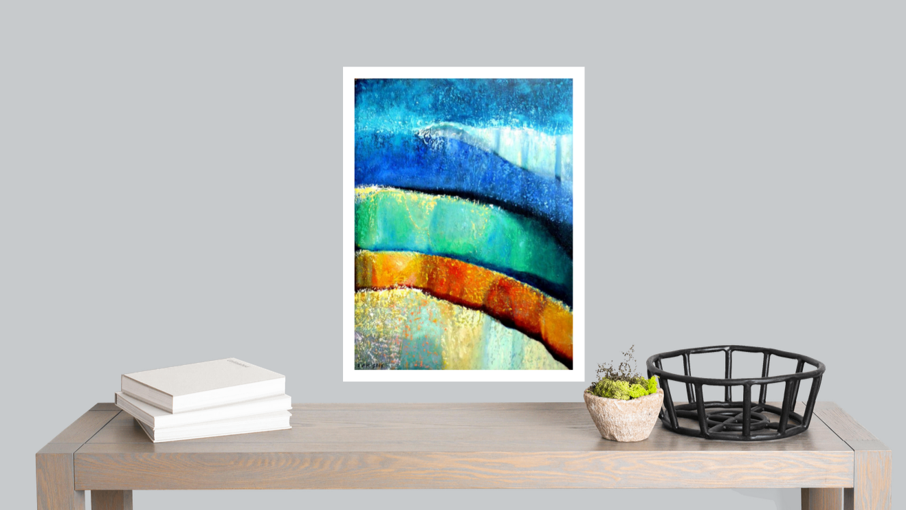 Framed abstract artwork on a wall above a wooden table with books and decor items.