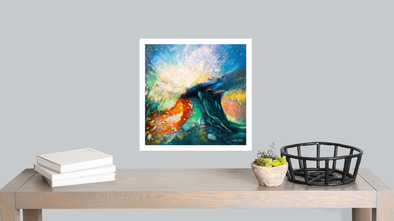 Framed abstract artwork on a wall above a wooden table with books and decorative items.